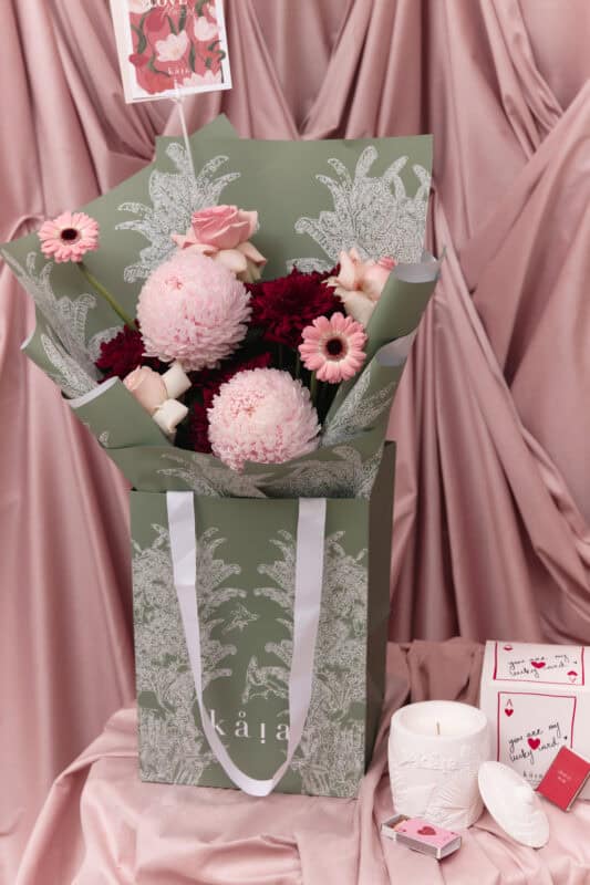 Elegant floral arrangement with pink roses, chrysanthemums, and gerbera daisies in a stylish green wrapping. Perfect for expressing love and affection.