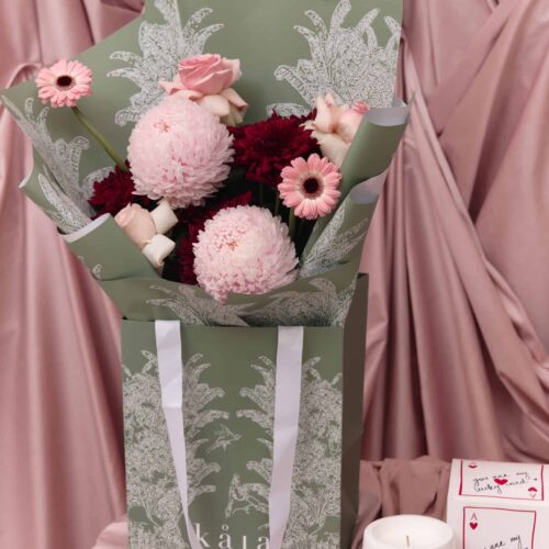Elegant floral arrangement with pink roses, chrysanthemums, and gerbera daisies in a stylish green wrapping. Perfect for expressing love and affection.