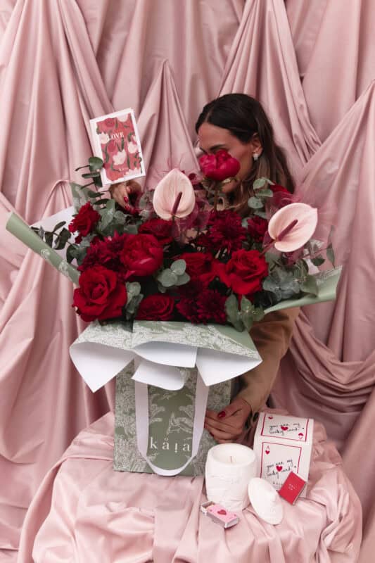 Beautiful floral arrangement with red roses, pink anthuriums, and greenery, perfect for celebrating love and special moments.
