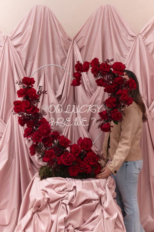 Elegant floral display with red roses and greenery for a romantic celebration.