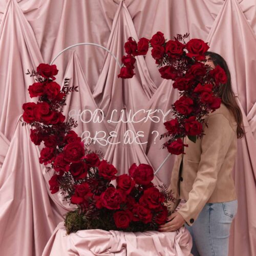 Elegant floral display with red roses and greenery for a romantic celebration.