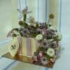 Elegant floral cake decorated with fresh flowers including roses, daisies, and lavender, perfect for celebrations and special occasions.