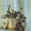 Beautiful floral cake decorated with fresh flowers and a heart-shaped topper with the number 30.
