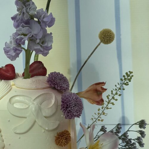 A beautiful floral arrangement featuring a variety of colorful flowers including pink, purple, yellow, and white blooms in a decorative vase. Perfect for weddings, events, or home decor.