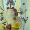 Elegant floral cake decorated with fresh flowers including lilies, daisies, and purple alliums, perfect for celebrations.