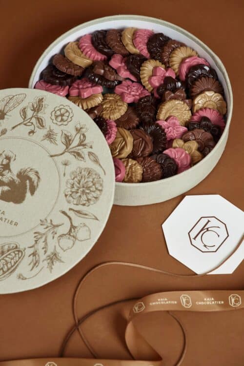 Elegant gift box filled with assorted chocolate florals in pink, brown, and beige, perfect for special occasions or as a luxurious treat.