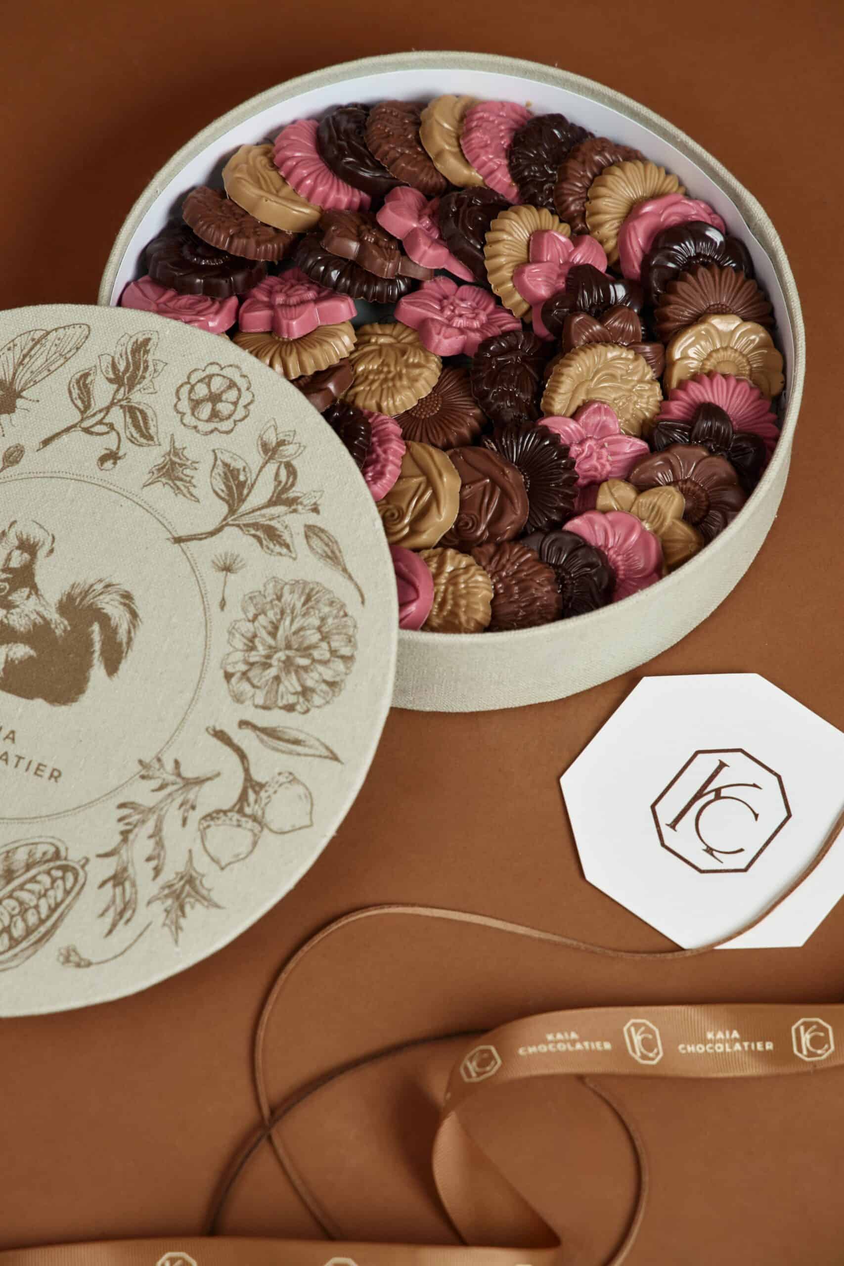 Elegant gift box filled with assorted chocolate florals in pink, brown, and beige, perfect for special occasions or as a luxurious treat.